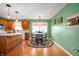 Bright kitchen and dining area with green walls, hardwood floors and matching table at 1114 Northfield Ln, Anderson, IN 46011