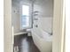 Bathroom featuring a freestanding tub, toilet, chrome fixtures, and a bright window at 1206 Dawson St, Indianapolis, IN 46203