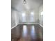 Sun-filled bedroom featuring dark wood floors, fresh gray walls, and new white trim around the windows at 1206 Dawson St, Indianapolis, IN 46203