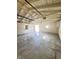Inside of the garage, featuring concrete floors, painted white walls, exposed rafters, and some natural light at 1206 Dawson St, Indianapolis, IN 46203