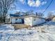 Back exterior view of white single-story house with snow covered yard at 1239 Brooks St, Indianapolis, IN 46202
