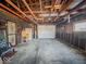 This basement features unfinished walls, concrete flooring, exposed utilities and a garage door at 1239 Brooks St, Indianapolis, IN 46202