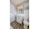 Bathroom featuring floral wallpaper, white tile, and a framed mirror over a vanity at 1239 Brooks St, Indianapolis, IN 46202