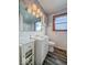 Bathroom with white tiled walls, patterned wallpaper, and a white vanity at 1239 Brooks St, Indianapolis, IN 46202