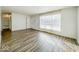 Open living room with wood-look floors, neutral paint, and a large window at 1239 Brooks St, Indianapolis, IN 46202