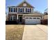 Two-story home featuring stone accents, neutral siding, shutters, and a two-car garage at 12461 Hawks Landing Dr, Fishers, IN 46037