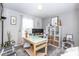Well-lit home office space featuring a glass-top desk, modern shelving, and neutral decor at 13414 Allegiance Dr, Fishers, IN 46037