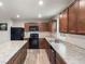 Kitchen with dark wood cabinets, an island, and updated black appliances at 13860 N Tiosa Ln, Camby, IN 46113