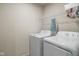 Functional laundry area with a washer, dryer, and overhead shelving at 13860 N Tiosa Ln, Camby, IN 46113