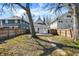 A partially fenced backyard with a deck, mature trees, and a lush lawn at 139 S Ritter Ave, Indianapolis, IN 46219