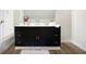 Bathroom vanity featuring a dark cabinet, white countertop, gold fixtures, and light wood flooring at 139 S Ritter Ave, Indianapolis, IN 46219