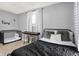 Cozy bedroom with a comfortable bed, crib and a stylish black and white curtain at 139 S Ritter Ave, Indianapolis, IN 46219
