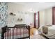 Bright bedroom featuring a comfortable bed, crib, and hardwood flooring at 139 S Ritter Ave, Indianapolis, IN 46219