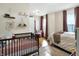 Bright bedroom featuring a comfortable bed, crib, and hardwood flooring at 139 S Ritter Ave, Indianapolis, IN 46219