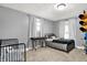 Charming bedroom featuring a comfortable bed, crib, and natural light with stylish grey walls at 139 S Ritter Ave, Indianapolis, IN 46219