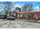Street view of commercial buildings with brick facades, parked cars, and lush green trees in the background at 139 S Ritter Ave, Indianapolis, IN 46219
