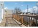 View of the wooden back deck, with wood railing, overlooking a neighborhood at 1413 S East St, Indianapolis, IN 46225