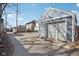 View of detached garage with a large garage door and long driveway in need of repair at 1413 S East St, Indianapolis, IN 46225