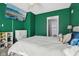 Green bedroom featuring bright windows, ceiling fan, and comfortable bedding and a TV at 1413 S East St, Indianapolis, IN 46225