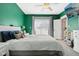 Green bedroom featuring bright windows, ceiling fan, and comfortable bedding at 1413 S East St, Indianapolis, IN 46225