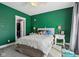 Green bedroom with a ceiling fan and a comfy bed with a white duvet cover and plush pillows at 1413 S East St, Indianapolis, IN 46225