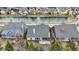 Aerial view of home with screened-in porch, patio, and lush backyard by the water at 15745 Market Center Dr, Carmel, IN 46033