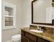 Bathroom with granite countertop, dark wood vanity, and a single window with shutters at 15745 Market Center Dr, Carmel, IN 46033