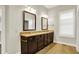 Double vanity in the bathroom with granite countertops, dark wood cabinets and decorative mirrors at 15745 Market Center Dr, Carmel, IN 46033