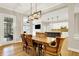 An open floor plan integrates dining room with kitchen, featuring wooden table and chairs, and hardwood floors at 15745 Market Center Dr, Carmel, IN 46033