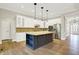 Bright kitchen features white cabinets, stainless appliances, large island, and hardwood floors at 15745 Market Center Dr, Carmel, IN 46033