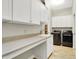 Bright laundry room featuring white cabinets, a sink, and front loading washer and dryer at 15745 Market Center Dr, Carmel, IN 46033