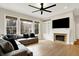 Comfortable living room features a gray sectional sofa, fireplace, hardwood floors, and bright windows at 15745 Market Center Dr, Carmel, IN 46033
