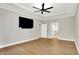 Main bedroom boasts wood floors, ceiling fan, TV, tray ceiling and neutral wall color at 15745 Market Center Dr, Carmel, IN 46033