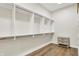 Walk-in closet featuring custom white shelving, hanging rods, and a small chest of drawers at 15745 Market Center Dr, Carmel, IN 46033