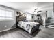 A cozy main bedroom with a wood accent bedframe and stairway access to other part of the house at 163 Country Wood Dr, Whiteland, IN 46184
