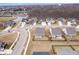 This aerial shows a suburban neighborhood with manicured lawns, modern houses, and a serene pond area at 16401 Brigham Ln, Westfield, IN 46074