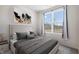 Stylish bedroom with neutral tones, a statement art piece, and a large window with bright natural light at 16401 Brigham Ln, Westfield, IN 46074