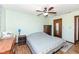 Cozy bedroom with a ceiling fan, wood floors, and access to an en-suite bathroom at 22569 State Road 37 N, Noblesville, IN 46060