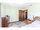Bedroom with light green walls, wood trim, and entry to another room at 22569 State Road 37 N, Noblesville, IN 46060