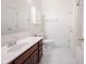 Bathroom vanity has a dark wood base, a large mirror, and a standard toilet at 2332 Brightwell Pl, Indianapolis, IN 46260
