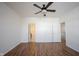 Spacious bedroom with wood-look flooring, a ceiling fan, and multiple access doors at 2332 Brightwell Pl, Indianapolis, IN 46260