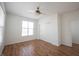 Bedroom featuring a ceiling fan, hardwood floors, and ample natural light from the large window at 2332 Brightwell Pl, Indianapolis, IN 46260