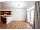 Dining area with wood floors, modern lighting, and door to patio at 2332 Brightwell Pl, Indianapolis, IN 46260