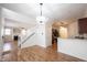 Open concept living room featuring wood floors, fireplace, staircase, and view into the kitchen at 2332 Brightwell Pl, Indianapolis, IN 46260