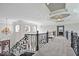 Bright upstairs hallway featuring beautiful railing design and view of the front door entryway at 2766 S Honey Creek S Rd, Greenwood, IN 46143