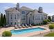 Backyard with a beautiful in-ground pool, lounge chairs, manicured bushes, and a patio at 2766 S Honey Creek S Rd, Greenwood, IN 46143