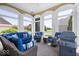 Cozy sunroom featuring comfortable blue seating, large windows with a view and an outdoor grill at 2766 S Honey Creek S Rd, Greenwood, IN 46143