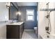 Bathroom featuring a double vanity with marble countertop, framed mirror, and shower/tub combo with patterned tile accents at 320 E 86Th St, Indianapolis, IN 46240