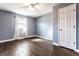 Well-lit bedroom featuring hardwood floors, a ceiling fan, and a window with sheer curtains for natural light at 320 E 86Th St, Indianapolis, IN 46240