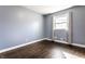 Comfortable bedroom with hardwood floors, a bright window, and blue walls providing a calm, relaxing space at 320 E 86Th St, Indianapolis, IN 46240